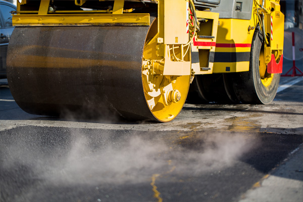 Heavy-duty paving equipment in operation on a road construction site