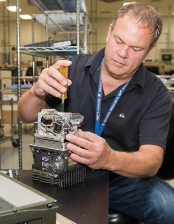 Engineer assembling and evaluating electromechanical prototype hardware