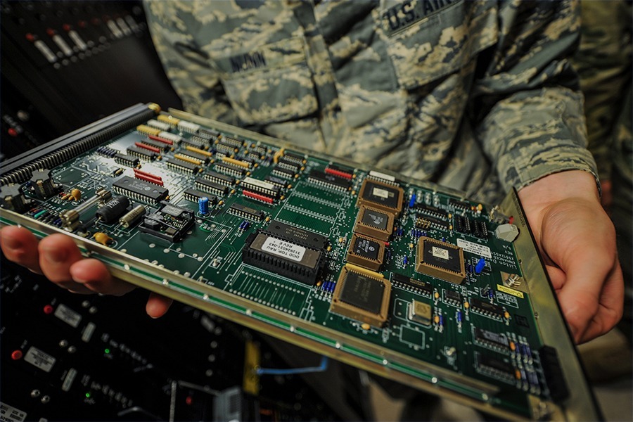 Technician inspecting a legacy electronic circuit board