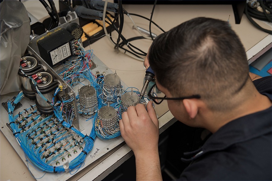 Engineer assembling and testing avionics electronics