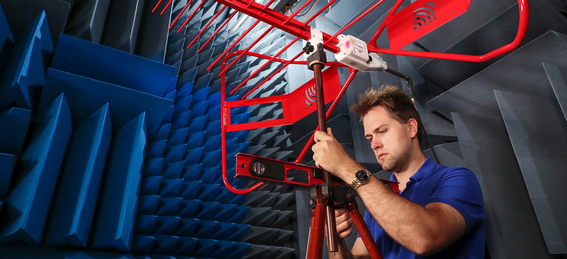 Engineer testing antenna equipment in an anechoic chamber