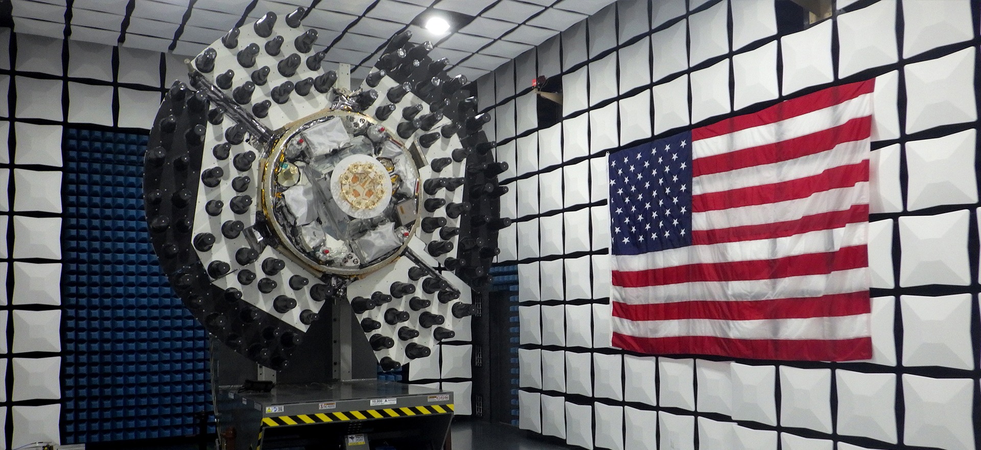 Aerospace communications hardware undergoing testing in an anechoic chamber